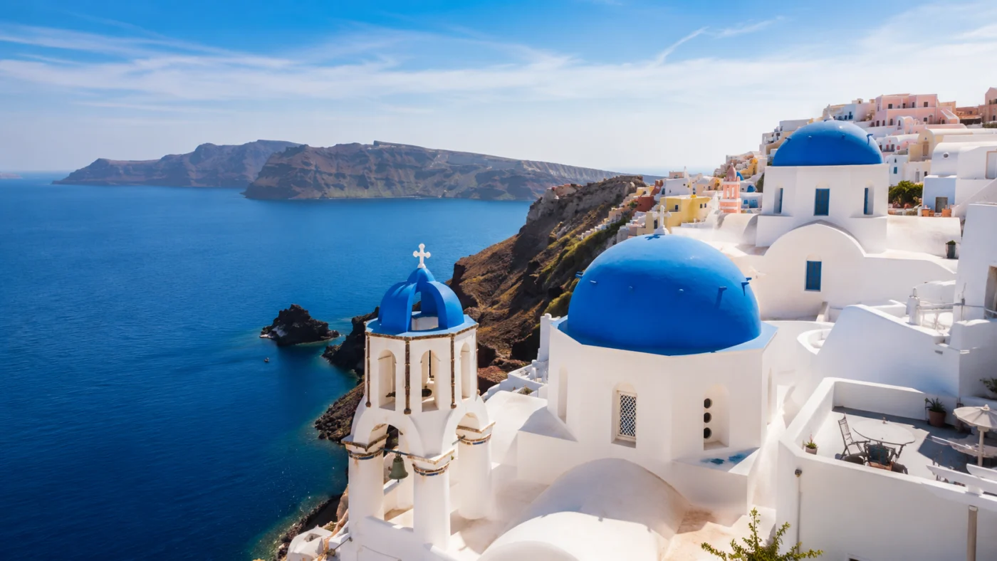 Witte kerken met blauwe koepels boven de blauwe zee op Santorini, Griekenland