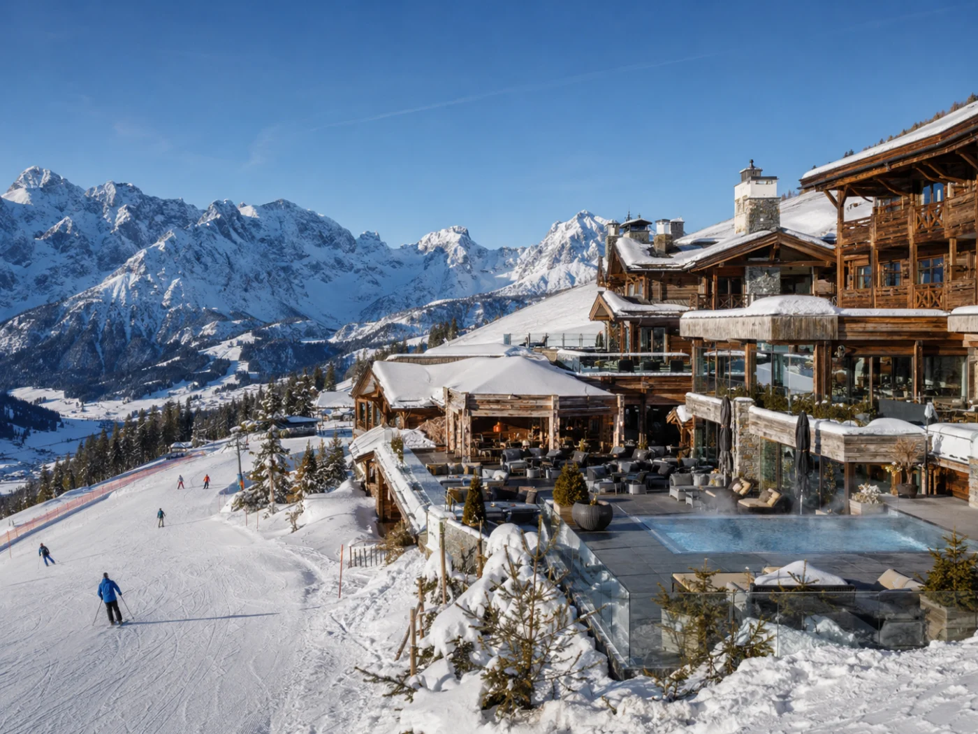 Chalethotel met verwarmd buitenzwembad en loungeterras direct aan de piste in de Oostenrijkse Alpen, met skiërs en besneeuwde bergtoppen