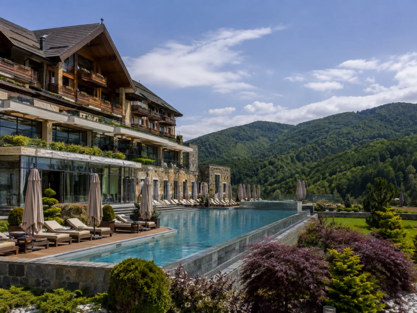 Bergresort met infinity pool en ligbedden tussen de groene beboste heuvels van de Karpaten in Roemenië