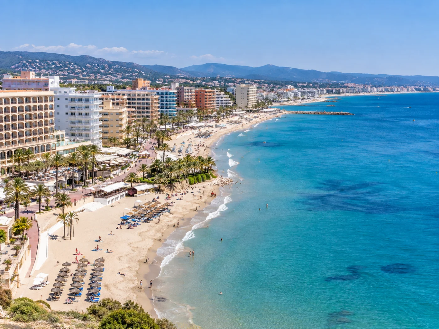 Boulevard met all inclusive strandhotels en palmen direct aan een breed zandstrand met helderblauwe zee