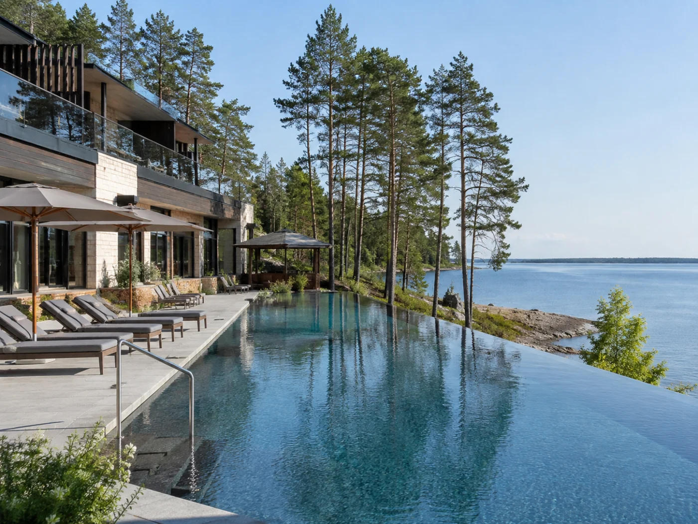 Modern wellnesshotel met infinity pool en ligbedden tussen dennenbomen aan de rotsige Oostzeekust van Estland